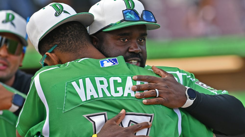 Dragons manager Vince Harrison Jr. hugs shortstop Alexander Vargas after Sunday's 3-1 win at Day Air Ballpark in the season's final game.