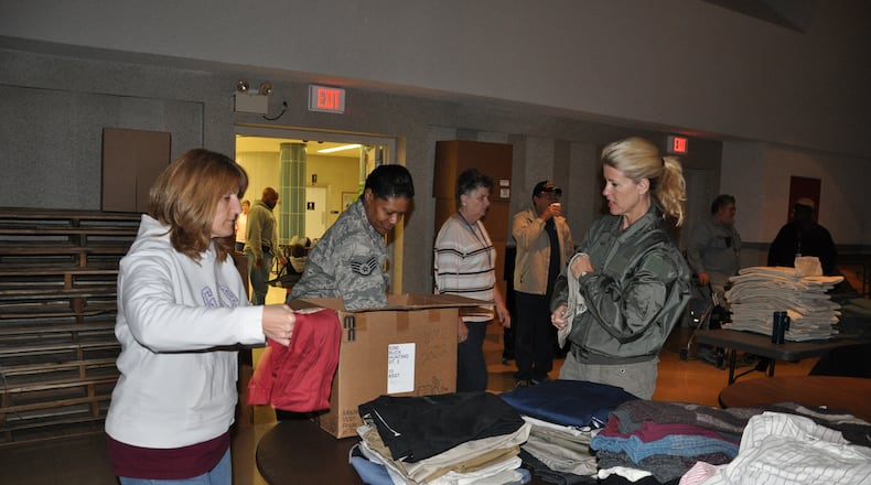 From left, Tech. Sgt. Eugenie Hinson, 445th Airlift Wing historian craftsman, Staff Sgt. Jawahna Hollins, 445th Airlift Wing executive assistant to the command chief, and Senior Master Sgt. Kelly Janus, 445th Aerospace Medicine Squadron medical services technician, unpack and sort through clothing for the 2012 Dayton Veteran’s Affairs Homeless Stand Down event. Air Force photo/Lt. Col. Cynthia Harris