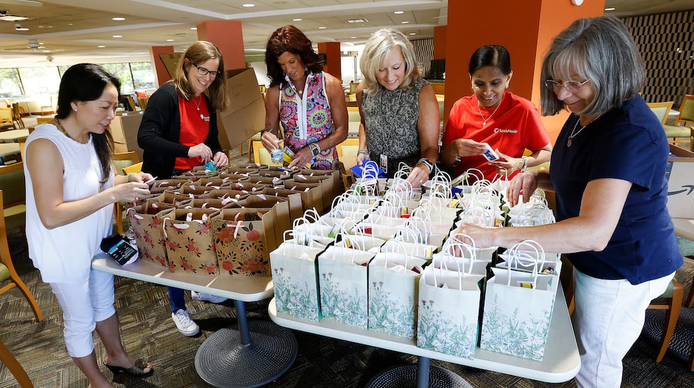 This team of ladies, From left, Tam Dowd, Community Gem Karen Westgerdes, Rene' Chase, Stephanie Singer, Rekha Vira and Pam Berg, pack street bangs at Lexis Nexis. The bags are made to help women on the streets and to combat sexual trafficking. MARSHALL GORBY/STAFF