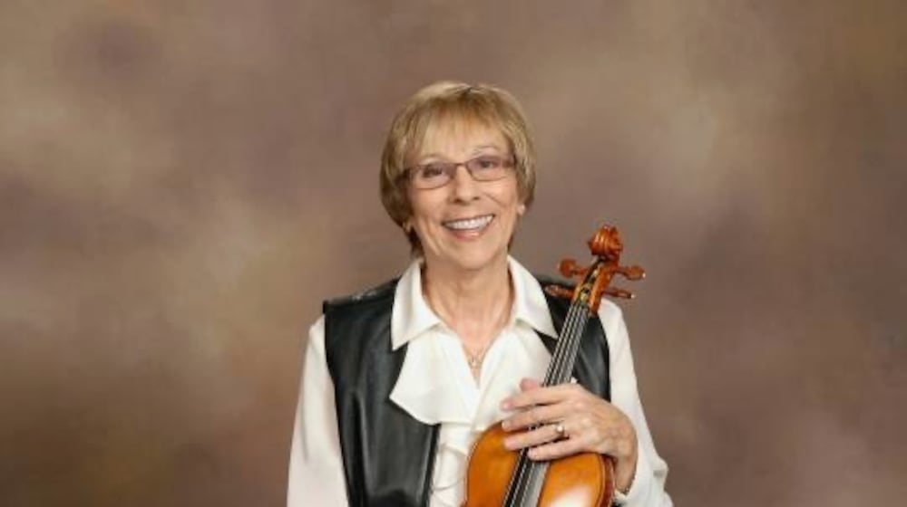 Melinda Hofstetter plays the violin over the phone for members of her church who can't attend services.