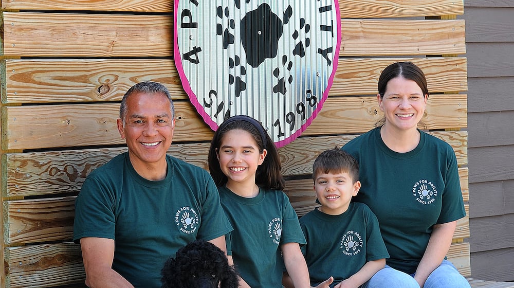 The Tibuni Family, from left, Daniel, Emerson, age 10, Branson, age 6, and Kandice, and sitting in front is 2-year-old Tamera, a standard Poodle. The family all volunteer at 4 Paws For Ability in Xenia. MARSHALL GORBY\STAFF