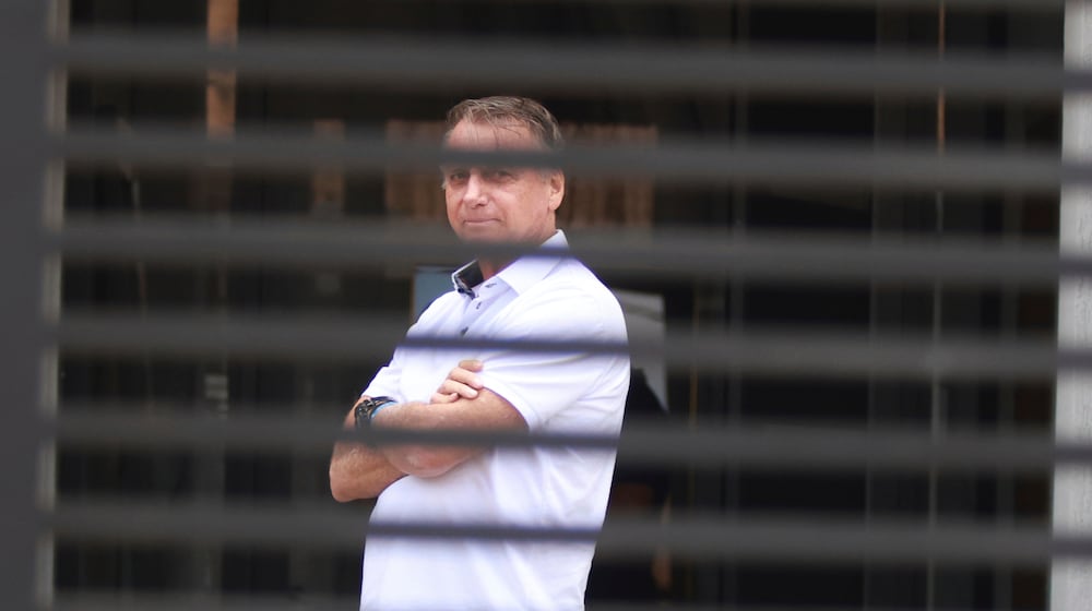Brazil's former President Jair Bolsonaro stands at the entrance of his home where he is under house arrest in Brasilia, Brazil, Tuesday, Sept. 2, 2025. (AP Photo/Luis Nova)