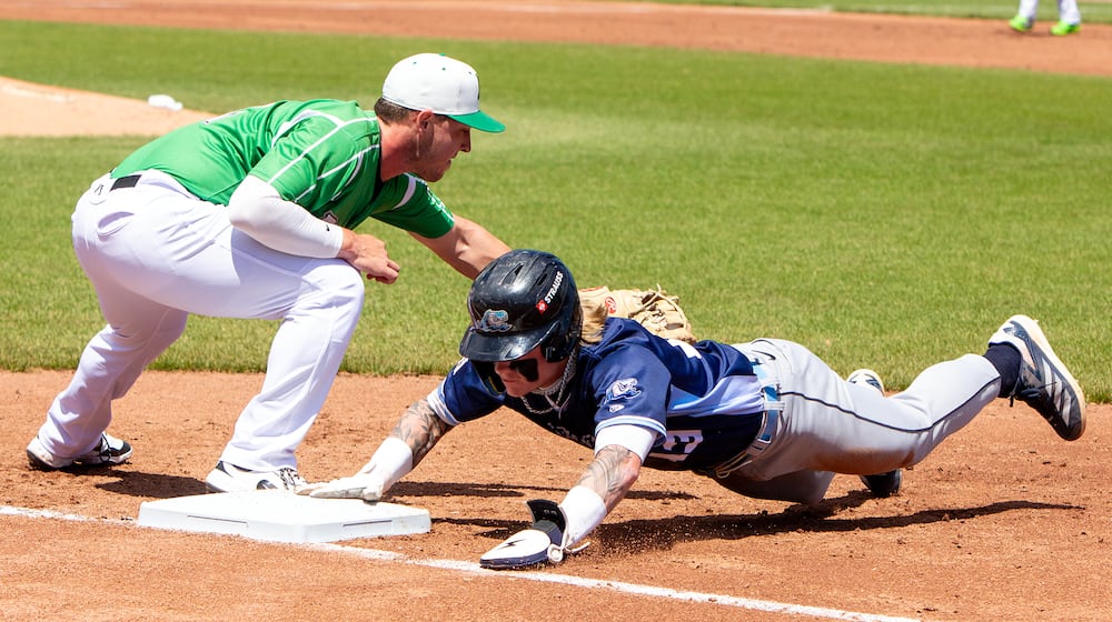 West Michigan's Max Clark dives safely back into first on a pickoff attempt ahead of the tag by Dayton first baseman John Michael Faile during their game on April 27, 2025 at Day Air Ball Park. JEFF GILBERT/CONTRIBUTED