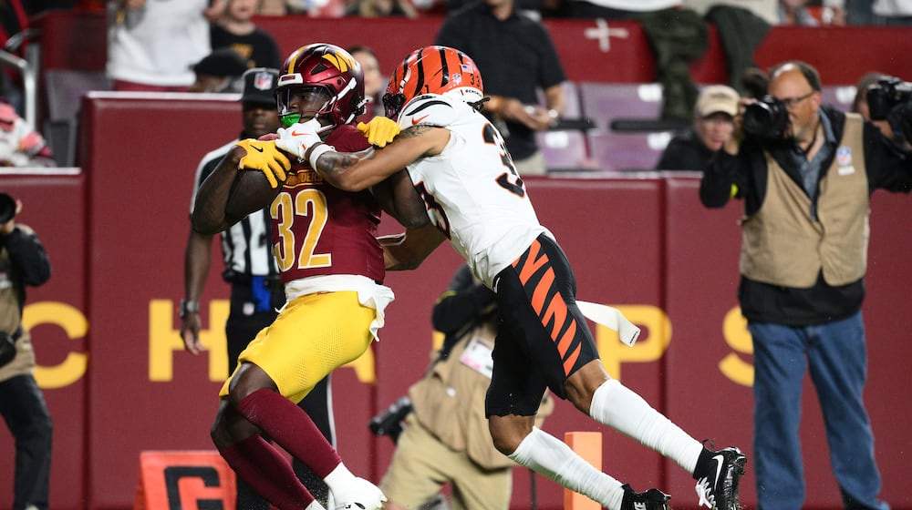 Washington Commanders running back Jacory Croskey-Merritt (32) scores past Cincinnati Bengals safety Daijahn Anthony during the first half of a preseason NFL football game Monday, Aug. 18, 2025, in Landover, Md. (AP Photo/Nick Wass)