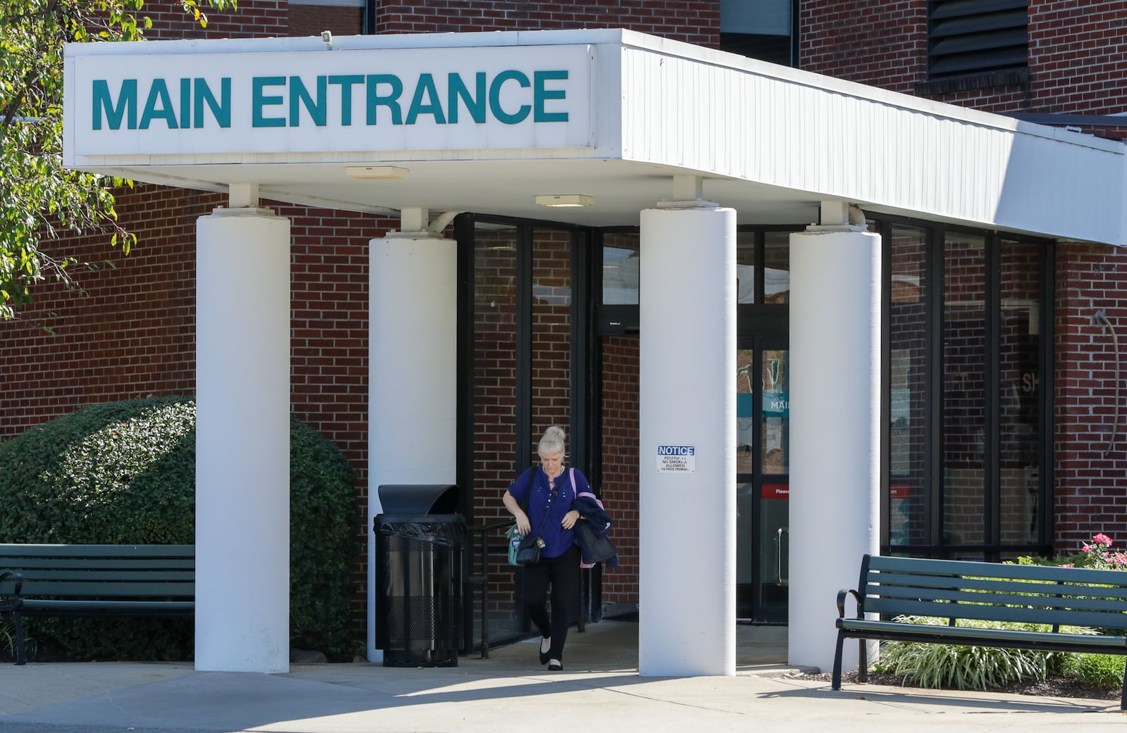A woman walks out of the main entrance of Greene Memorial Hospital in Xenia on Monday, Sept. 8. Kettering Health will invest $10 million in upgrades and renovations into the hospital under a new plan. BRYANT BILLING / STAFF