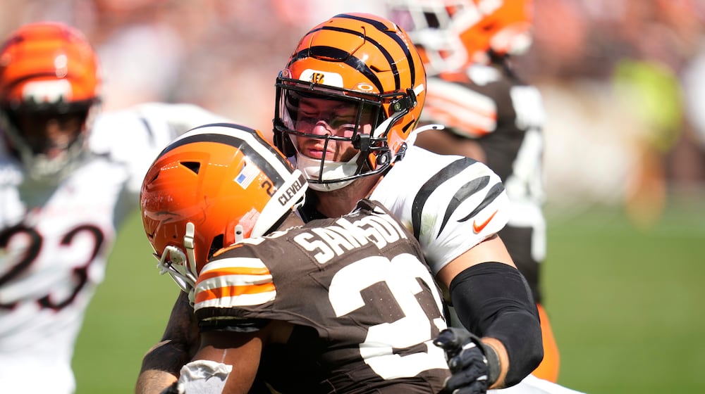 Cincinnati Bengals linebacker Logan Wilson, top, tackles Cleveland Browns running back Dylan Sampson (22) during the second half of an NFL football game Sunday, Sept. 7, 2025, in Cleveland. (AP Photo/Sue Ogrocki)