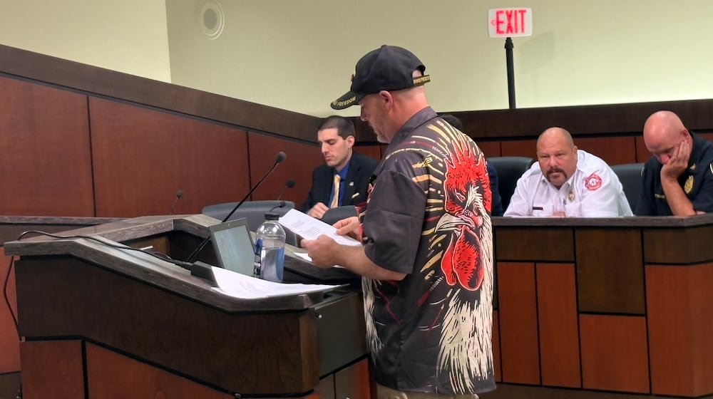 Kettering veteran Todd Combs makes a presentation to Kettering City Council Tuesday, Sept. 9, 2025, during a public hearing for an appeal of a Board of Zoning Appeals ruling that zoning administrators did not err in determining his backyard chickens violate city rules. In background is City Planner Ryan Homsi, left, Fire Chief Mitch Robbins and Police Chief Chip Protsman. JEN BALDUF/STAFF