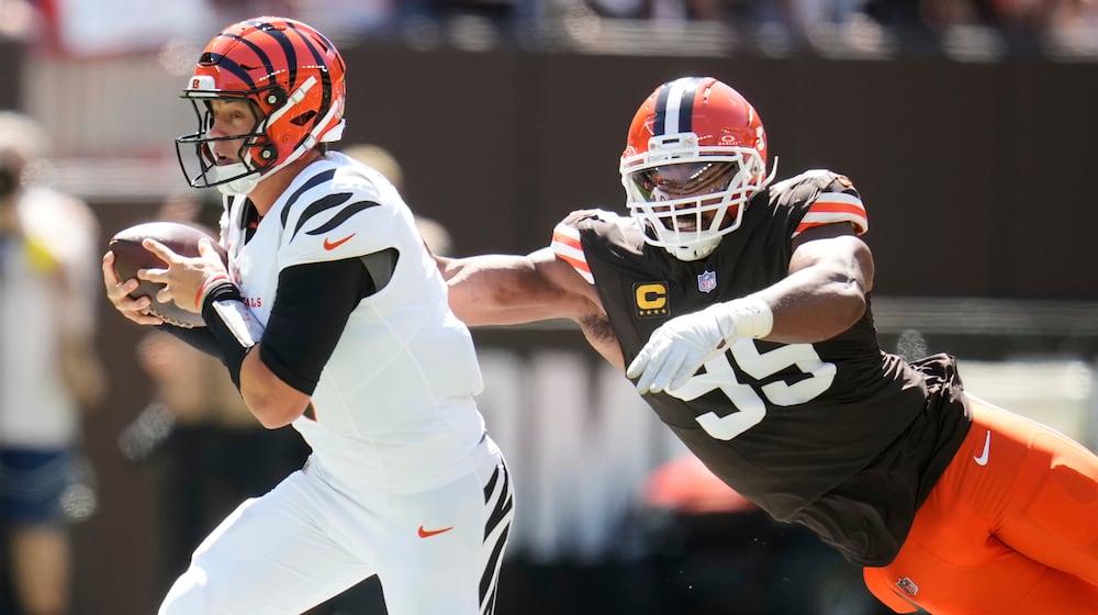 Cincinnati Bengals quarterback Joe Burrow, left, is tackled by Cleveland Browns defensive end Myles Garrett (95) during the first half of an NFL football game Sunday, Sept. 7, 2025, in Cleveland. (AP Photo/Sue Ogrocki)