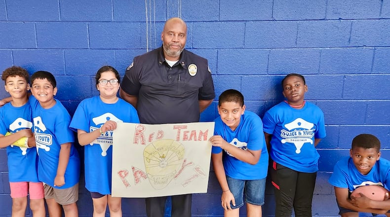 Trotwood Police Officer Tyrone Derrick with students from one of his police explorer program classes. CONTRIBUTED