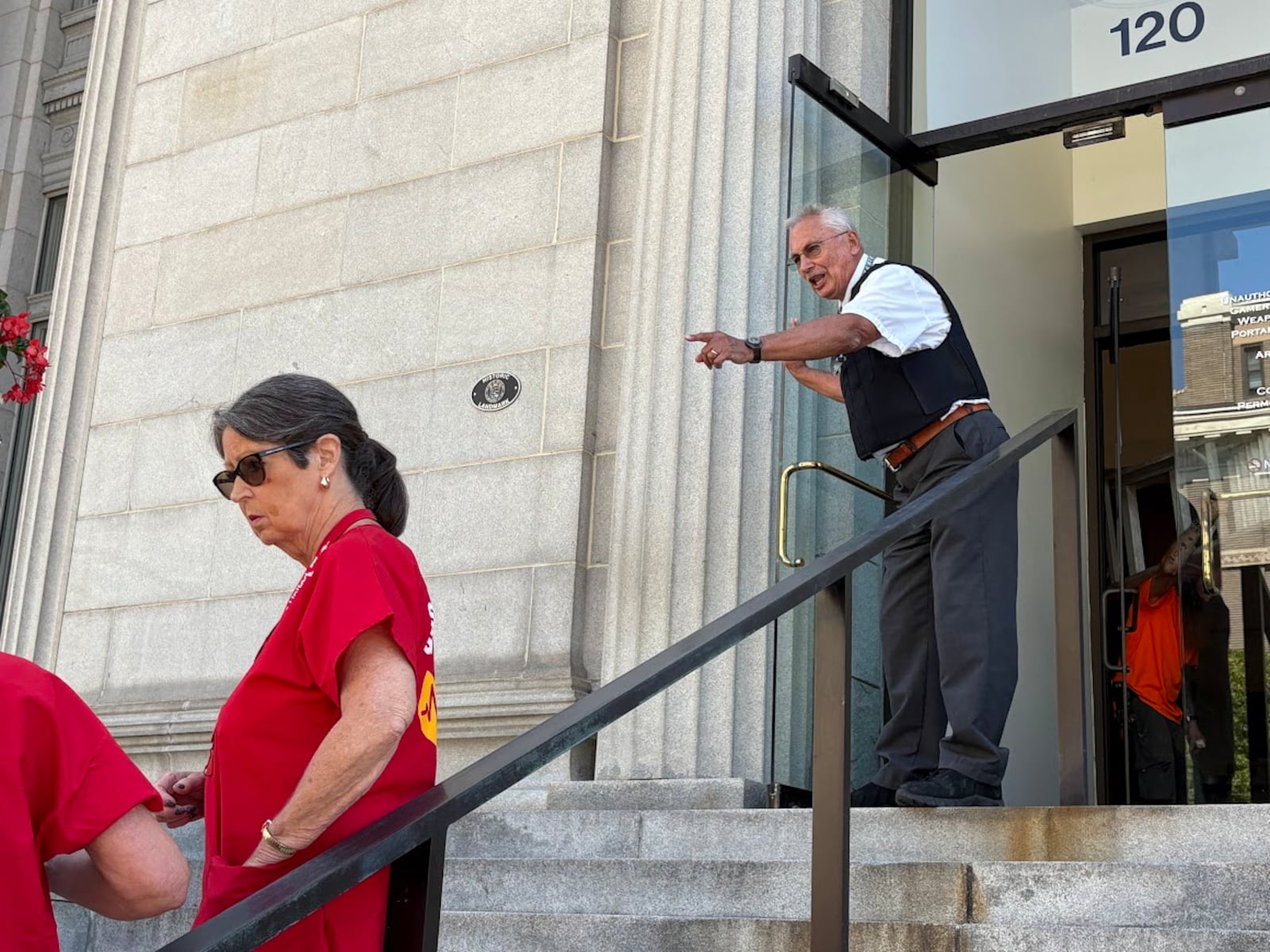 A security employee tells protesters that only two of them may meet with staff of U.S. Rep. Mike Turner after a rally in downtown Dayton on Friday, Sept. 12, 2025. THOMAS GNAU/STAFF