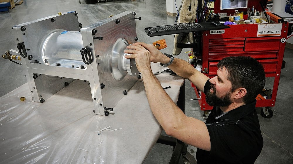 Spintech employee Abe McNutt, works on one of the parts that the company manufactures at their new facility in Miamisburg. MARSHALL GORBY\STAFF