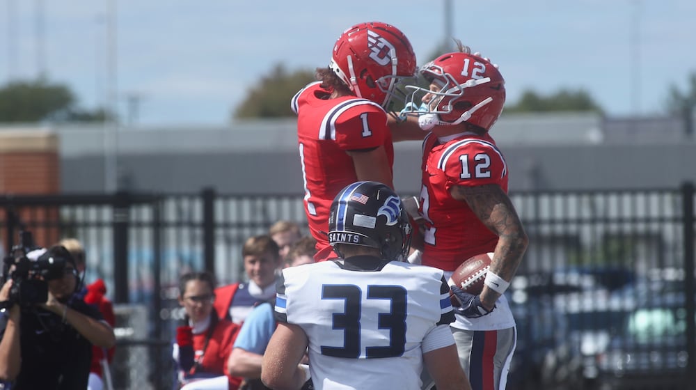 Dayton's Michael Mussari, left, and Gavin Lochow celebrate after a touchdown catch by Lochow against Thomas More on Saturday, Sept. 6, 2025, at Welcome Stadium. David Jablonski/Staff