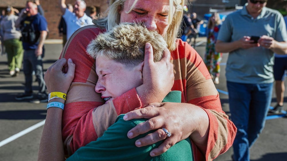 A parent hugs her son during an active shooter situation at the Annunciation Church in Minneapolis, Minn., Wednesday, Aug. 27, 2025. (Richard Tsong-Taatarii/Star Tribune via AP)