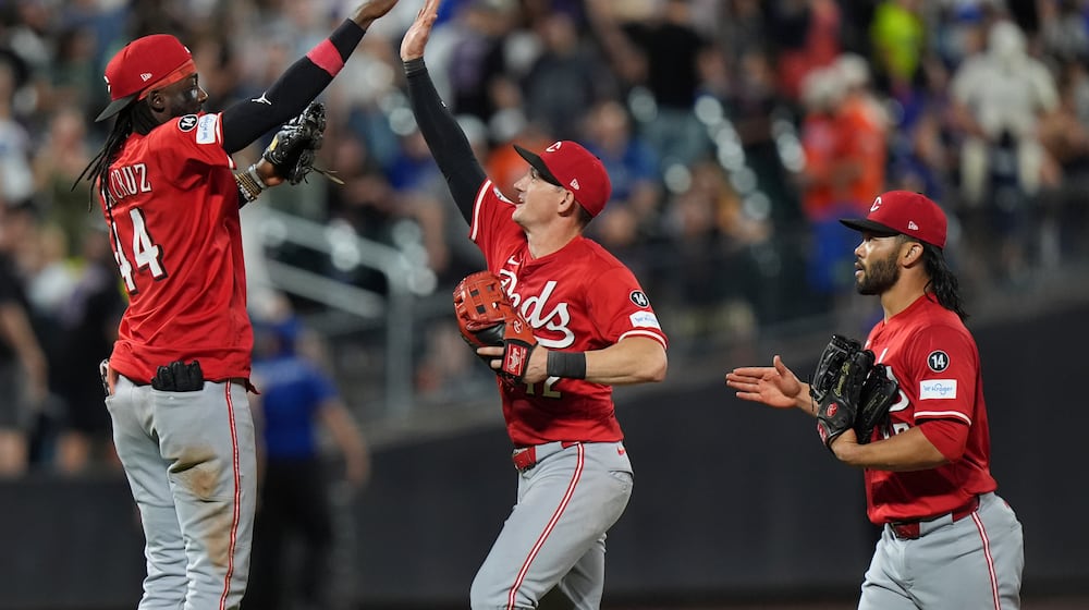 Cincinnati Reds' Elly De La Cruz, left, celebrates with Austin Hays, center, and Connor Joe after a baseball game against the New York Mets Friday, July 18, 2025, in New York. (AP Photo/Frank Franklin II)