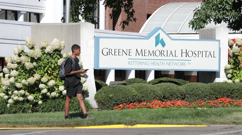 A boy walks in front of a sign in front of Greene Memorial Hospital on Monroe Drive in Xenia on Monday, Sept. 8. Kettering Health will invest $10 million in upgrades and renovations into Greene Memorial Hospital under a new plan. BRYANT BILLING / STAFF
