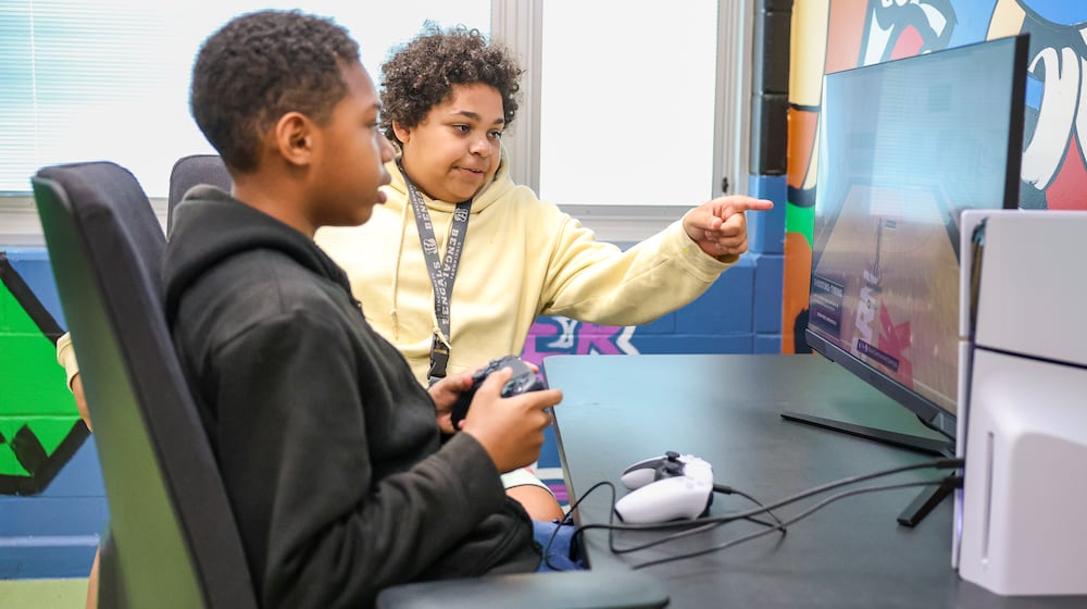 Karaun Ward points to an area on the screen while Jordan Freeman plays NBA 2K on a Playstation 5 in the game room at Westwood Elementary School on Thursday, Sept. 4 in Dayton. Ward and Freeman are both sixth graders and among students who played in the room in its first week after being unveiled. Principal SeMone Epps said the game room, which also has chess boards and other games and will soon have Legos, helps students engage. BRYANT BILLING / STAFF