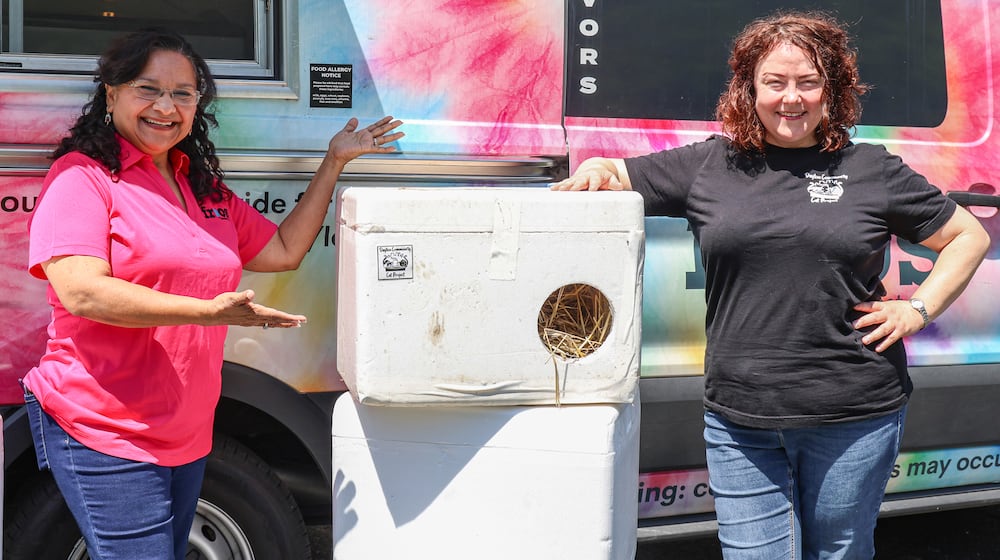 Augustina DeLeon (left), owner of Frios Popsicles, poses in front of one of her trucks with Chris Banks (right), who founded the Dayton Community Cat Project. DeLeon has been selected as a Dayton Daily News Community Gem for donating Styrofoam containers she uses to store popsicles to the charity, which converts them into shelters for stray cats. BRYANT BILLING / STAFF