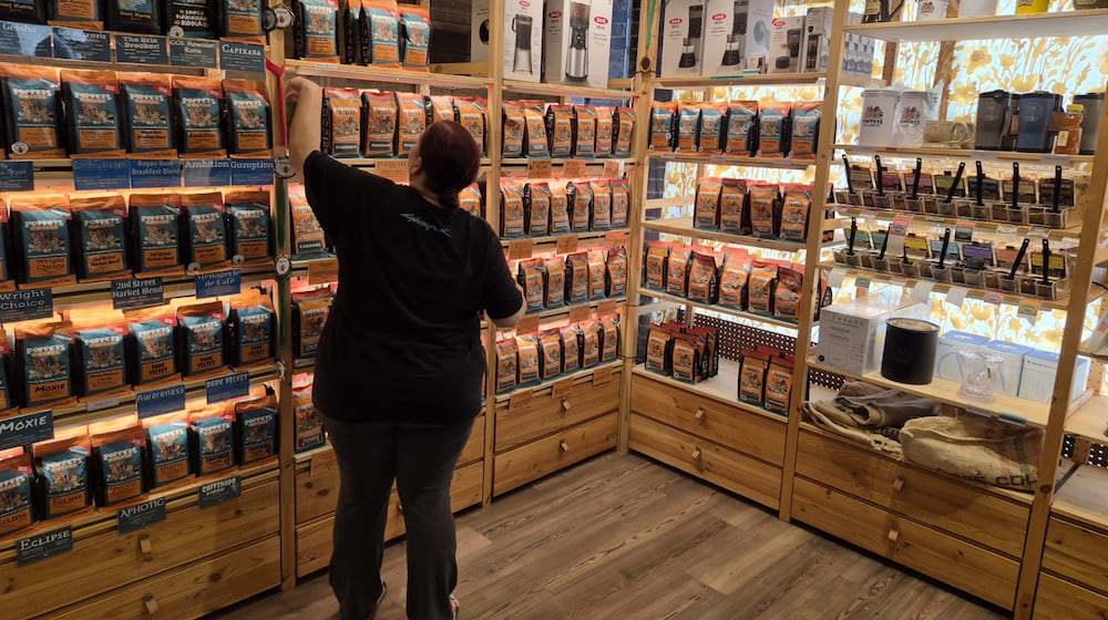 A clerk works with displays at Poppets Coffee and Tea's 2nd Street Market location. Poppets is opening a new location Oct. 13 in spite of tariff uncertainty. Michael Kurtz / Staff