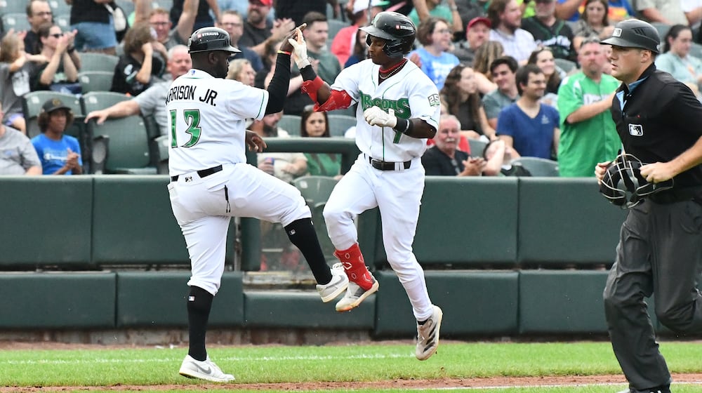 Dayton's Carlos Jorge is greeted by manager Vince Harrison Jr. after hitting a leadoff homer in the the third inning Saturday night at Day Air Ballpark. JEFF GILBERT/CONTRIBUTED
