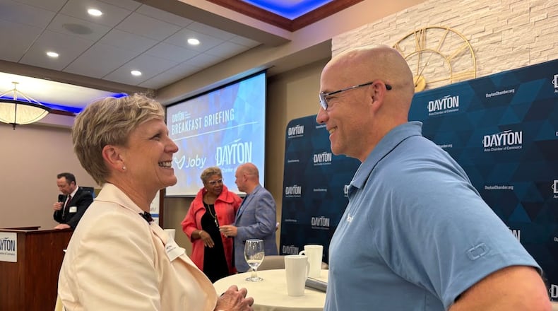 Janet Harp, vice president of stakeholder relations for the Dayton Development Coalition, shares a word with Thomas Ubelhart, the general manager of Joby Aviation's Joby Manufacturing of Ohio, after Ubelhart spoke during a Dayton Area Chamber of Commerce breakfast briefing Friday Sept. 12, 2025. THOMAS GNAU/STAFF