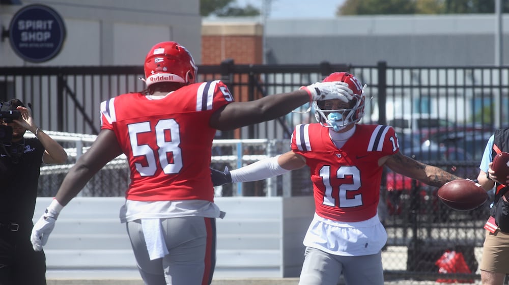 Dayton's Zachary McDowell, left, congratulates Gavin Lochow after a touchdown catch against Thomas More on Saturday, Sept. 6, 2025, at Welcome Stadium. David Jablonski/Staff