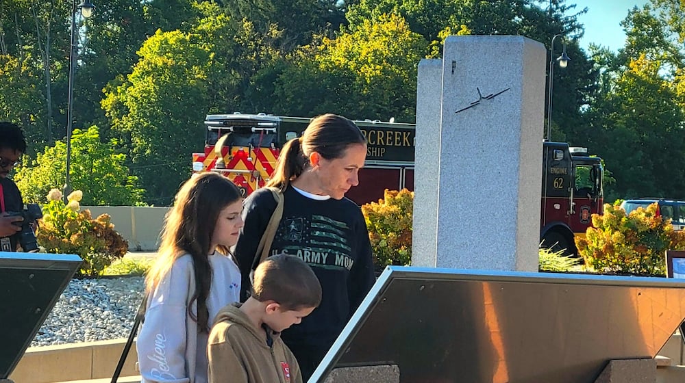 A young family looks on one of the displays at Beavercreek's 9/11 Memorial, Thursday, Sept. 11, 2025. LONDON BISHOP/STAFF