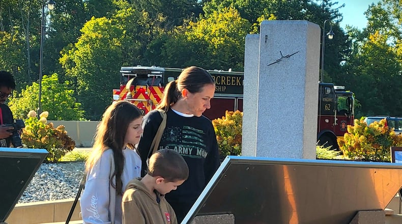 A young family looks on one of the displays at Beavercreek's 9/11 Memorial, Thursday, Sept. 11, 2025. LONDON BISHOP/STAFF