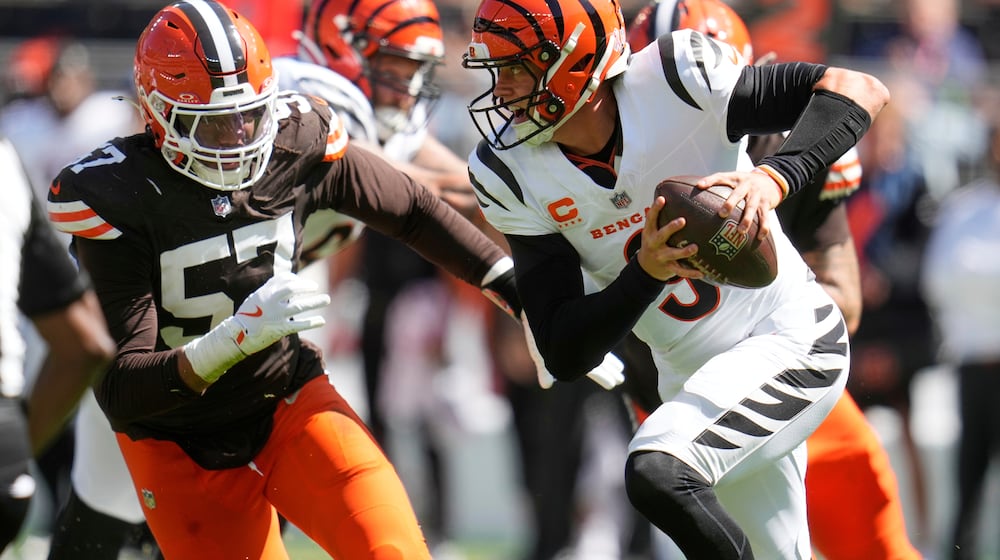 Cincinnati Bengals quarterback Joe Burrow (9) is chased by Cleveland Browns defensive end Isaiah McGuire (57) during the first half of an NFL football game Sunday, Sept. 7, 2025, in Cleveland. (AP Photo/Sue Ogrocki)
