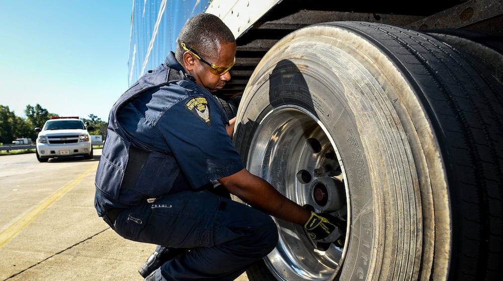 Ohio State Highway Patrol Motor Carrier Enforcement officer Thomas Hays performs a safety inspection Sept. 13 on a semi-truck at the rest area just south of the Monroe exit on southbound I-75 in Liberty Twp.