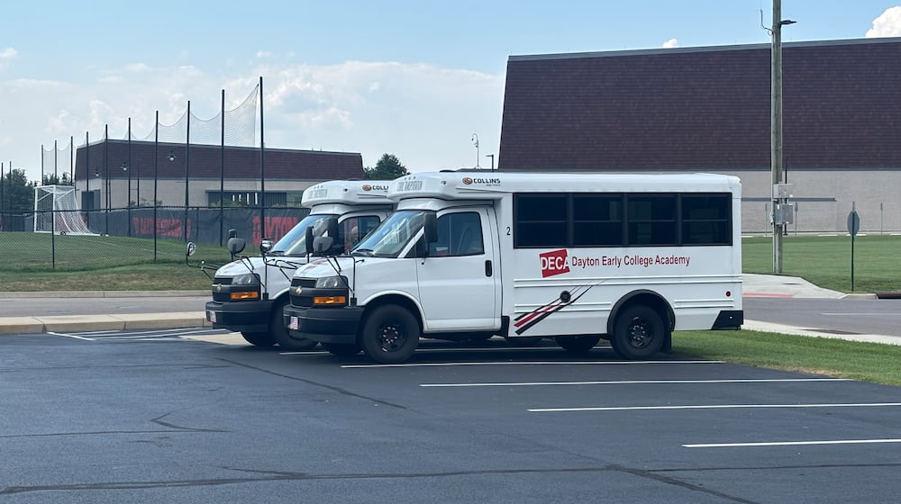 Two buses used to transport Dayton Early College Academy students sit in a lot outside of DECA High School Friday, Aug. 15. Eileen McClory/STAFF