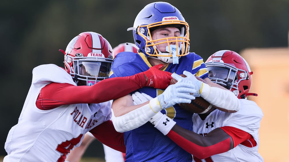 Lehman Catholic senior receiver Evan O'Leary runs while trying to fight off Northridge's Tre'von Rowe (left) and Sulaiman Muhhamed (right) during a Three Rivers Conference game  on Thursday, Sept. 11 at Sidney Memorial Stadium. The Cavaliers pulled away in the second half to a 34-16 win. BRYANT BILLING / STAFF
