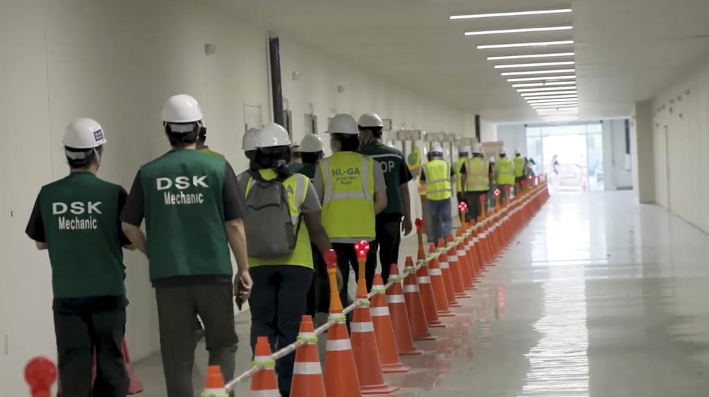 This image from video provided by U.S. Immigration and Customs Enforcement via DVIDS shows manufacturing plant employees being escorted outside the Hyundai Motor Group’s electric vehicle plant, Thursday, Sept. 4, 2025, in Ellabell, Ga. (Corey Bullard/U.S. Immigration and Customs Enforcement via AP)